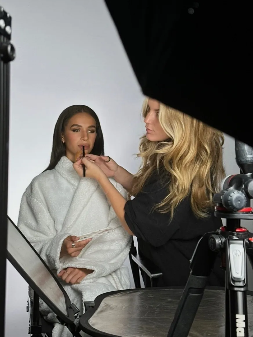 Zoë Elizabeth aplicando color de labios a una modelo en set