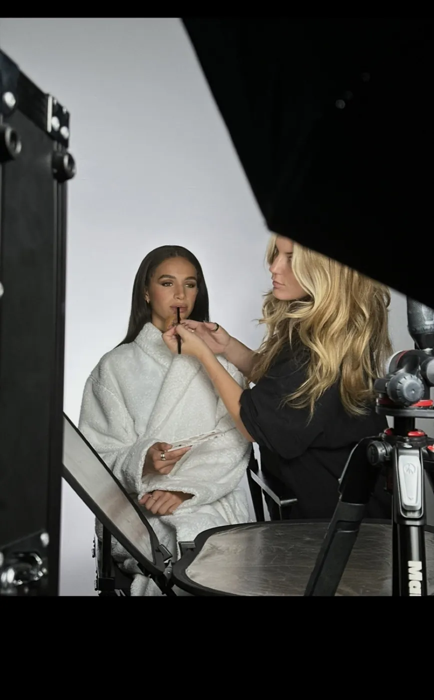 Zoë Elizabeth aplicando color de labios a una modelo en set