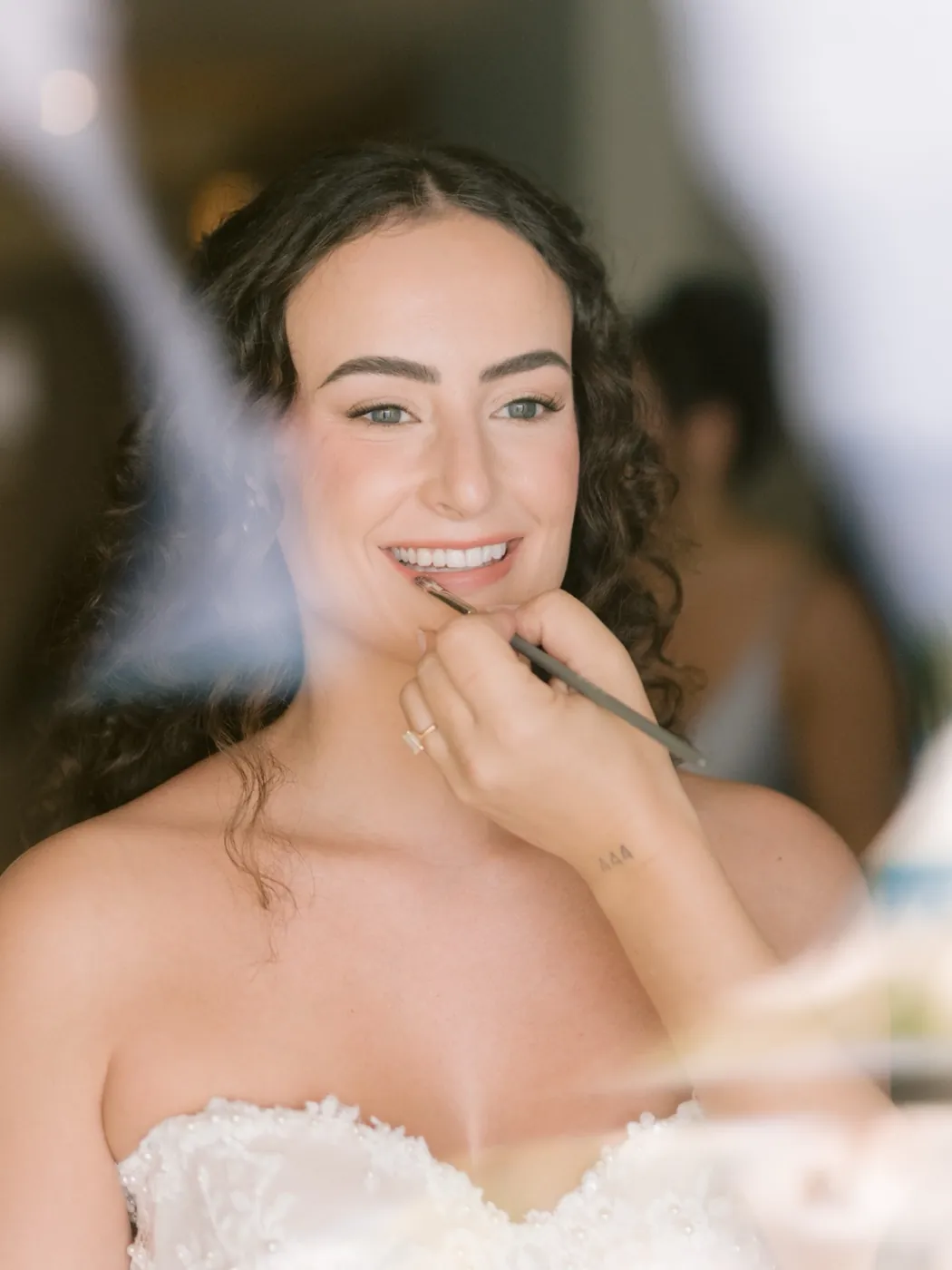 Novia sonriendo mientras le terminan los labios con pincel, Hyatt Ziva Cancún