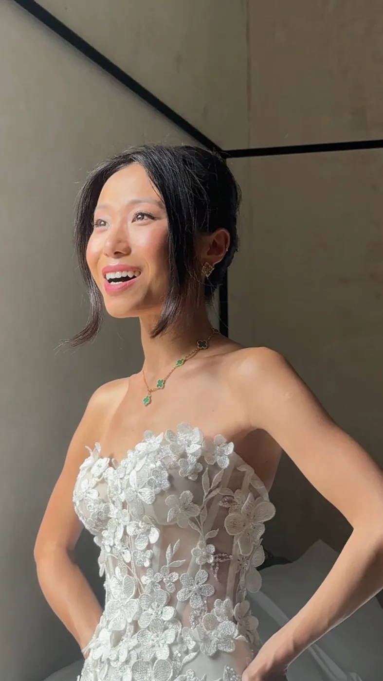 Connie riendo con vestido strapless floral y collar Van Cleef