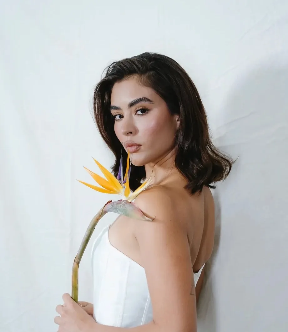 Novia con vestido strapless sosteniendo un ave del paraíso