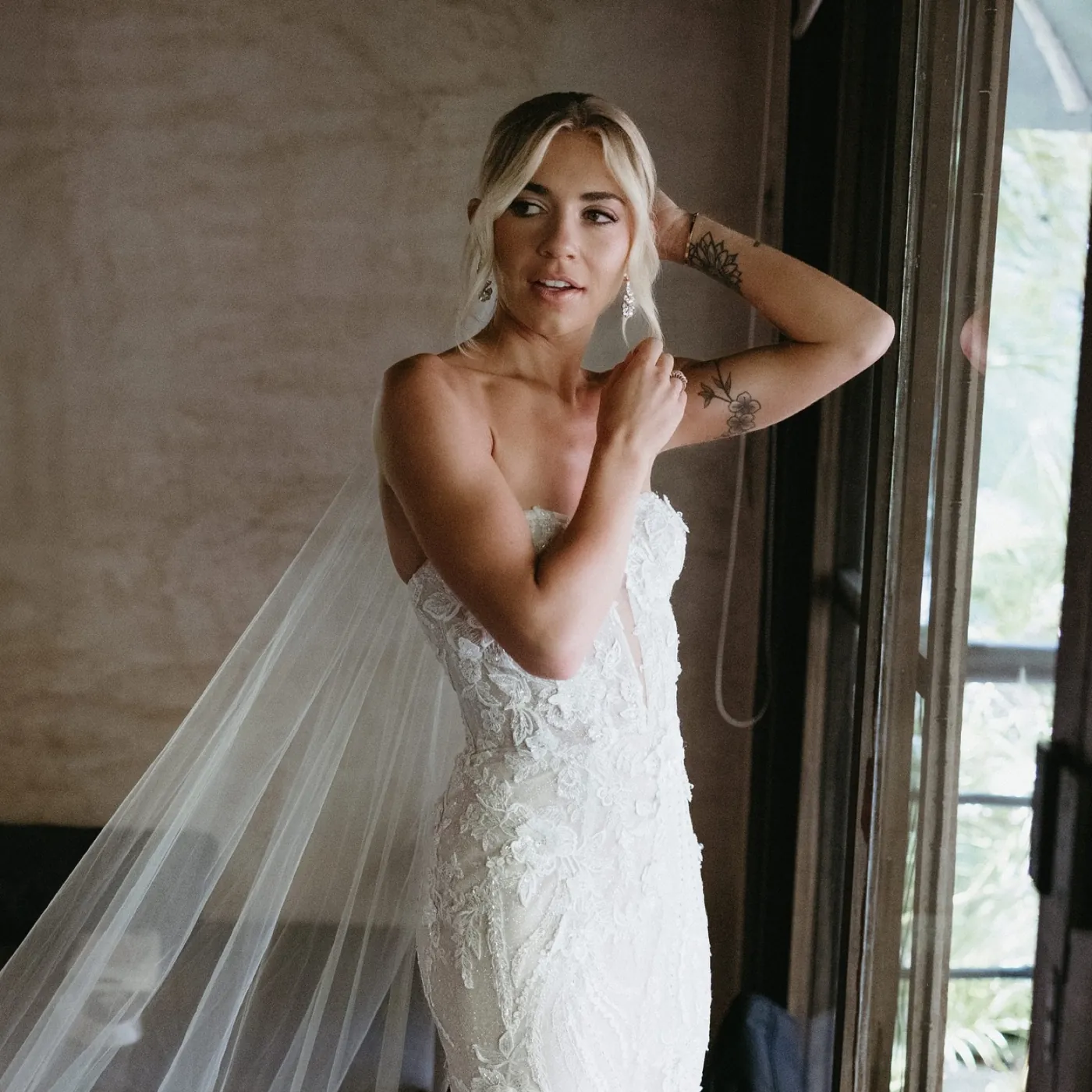 Novia con vestido strapless de encaje y velo catedral