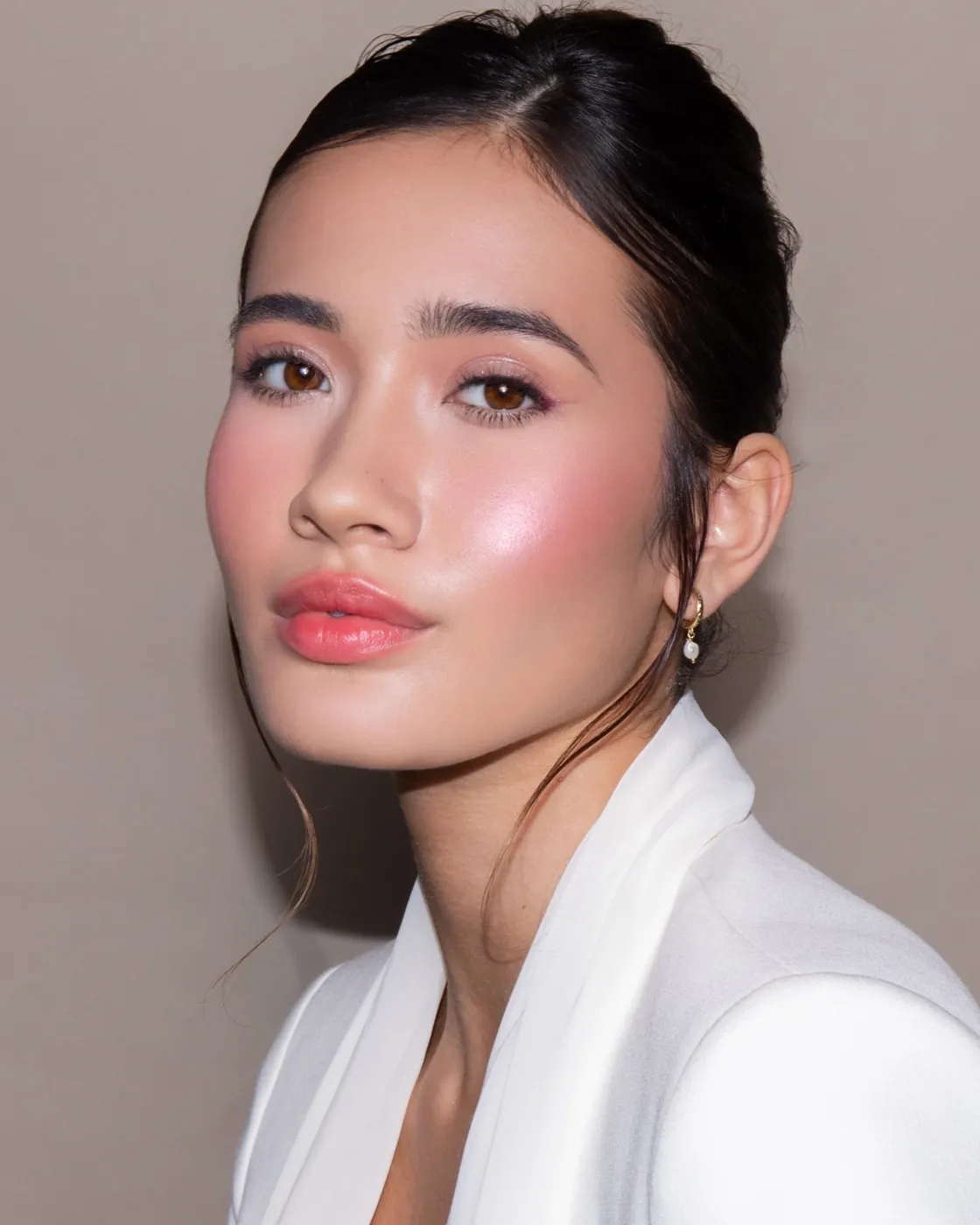 Labios color cereza y mejillas sonrojadas sobre piel luminosa, solapa blanca