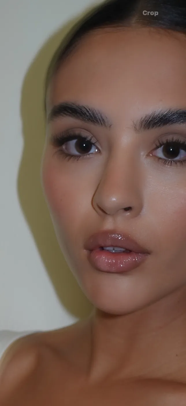 Primer plano de cejas definidas y labios nude con brillo